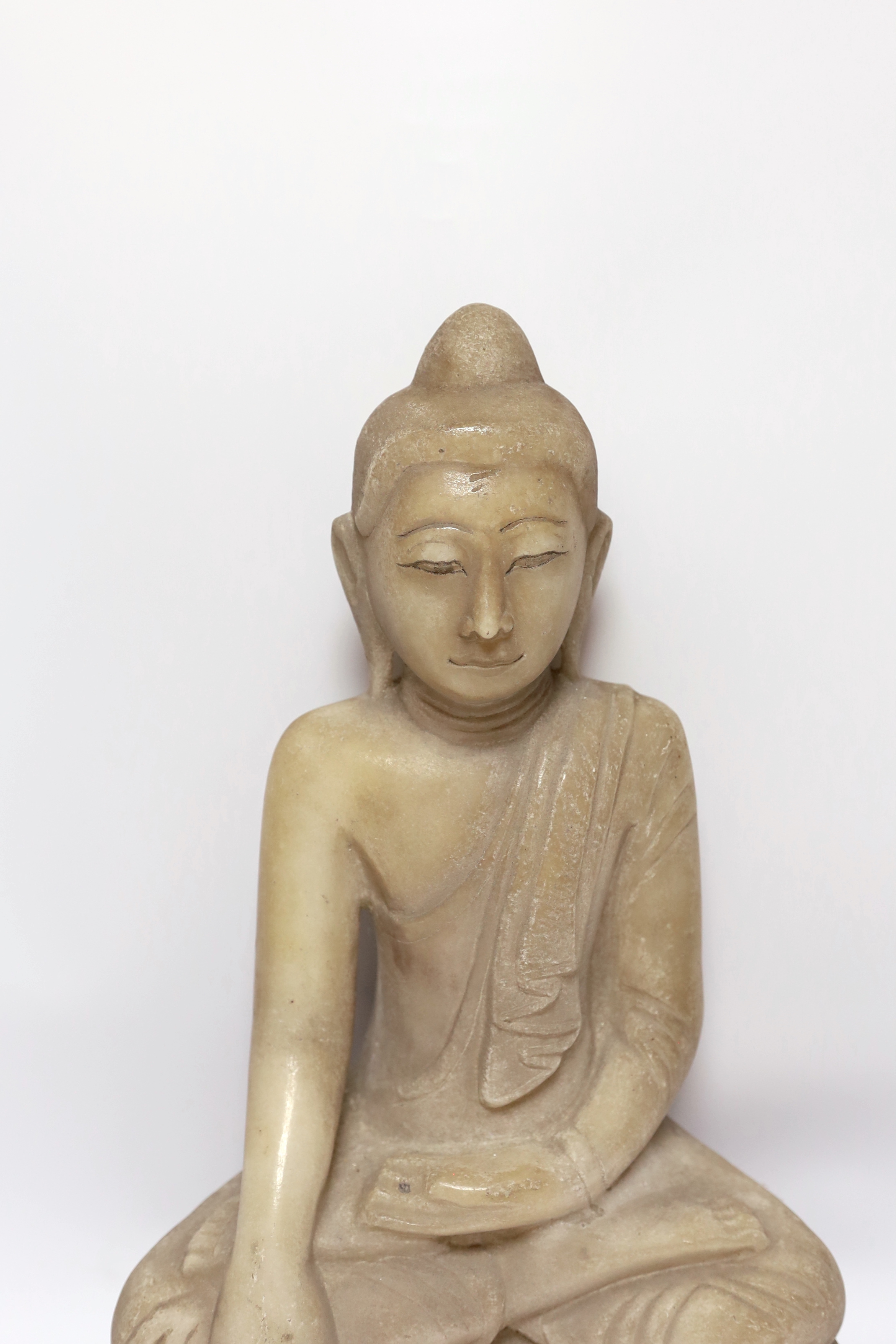 A Burmese carved alabaster model of a seated buddha, 46cm